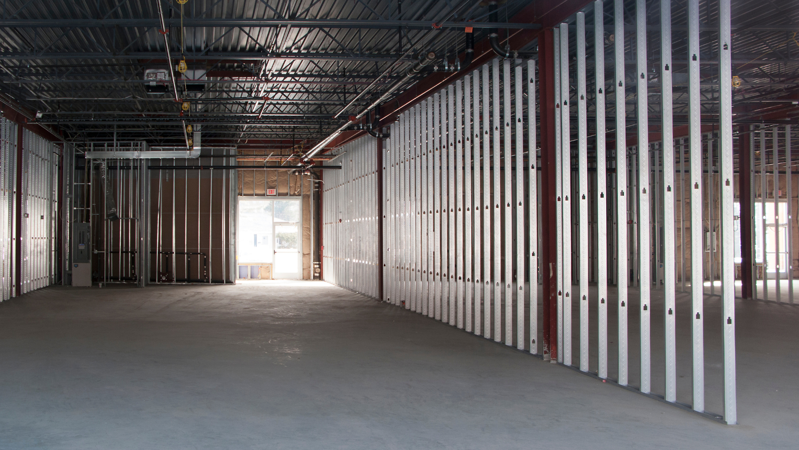 a large empty room in a building under construction .